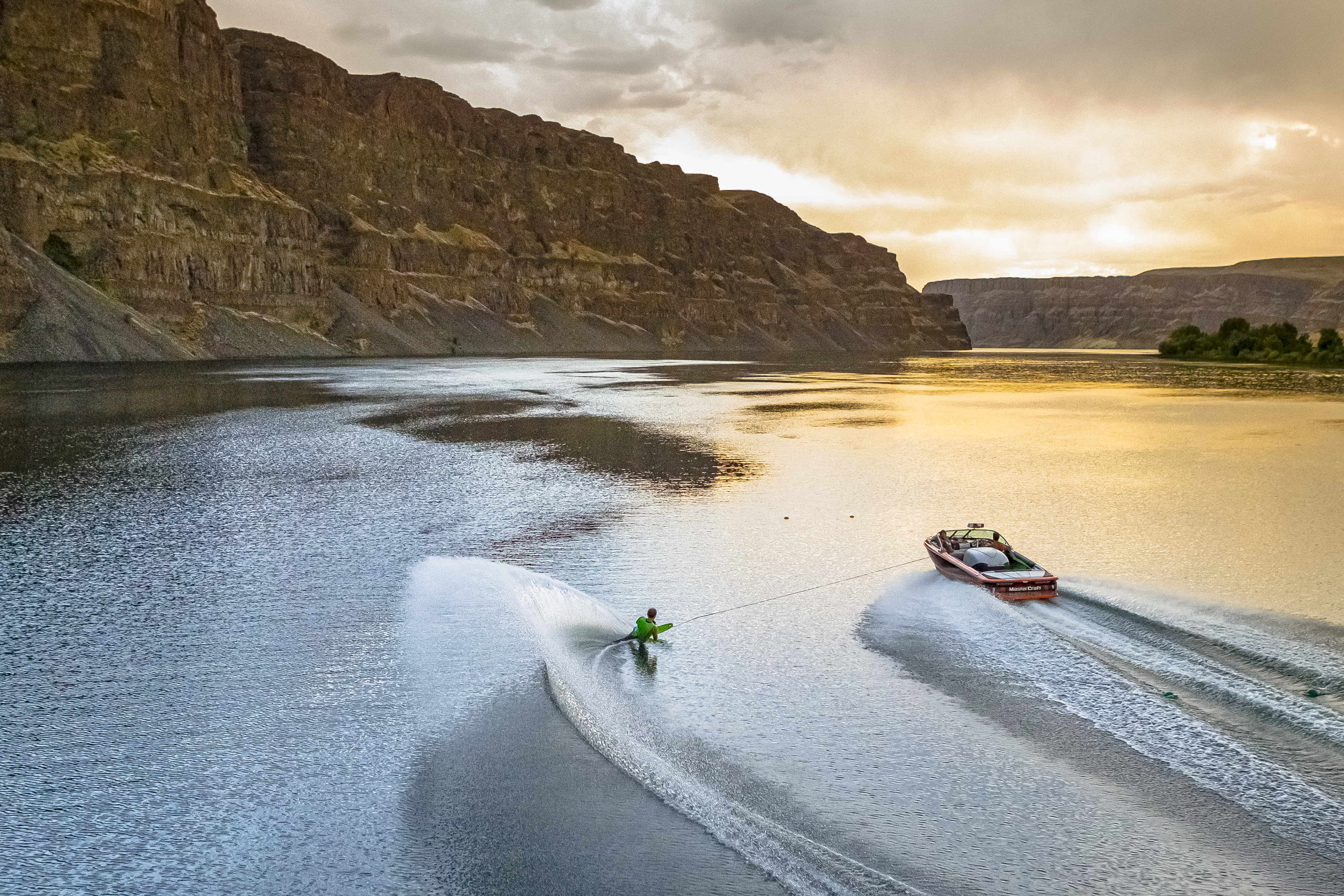 Boat and waterskier on the river at sunset